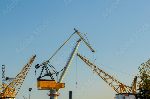 Wallpaper Mural Yellow construction cranes close-up. Blue sky and white clouds. Place for text. Selective focus image. Copy space. Torontodigital.ca