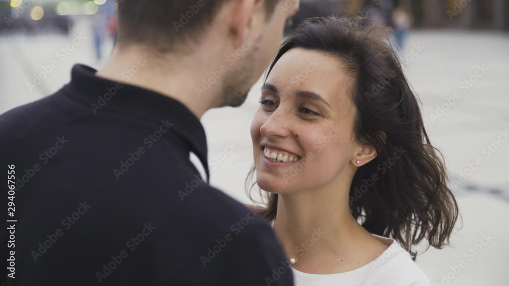 Portrait of attractive couple standing at the city street talking and smiling Portrait of attractive couple standing at the city street talking and smiling