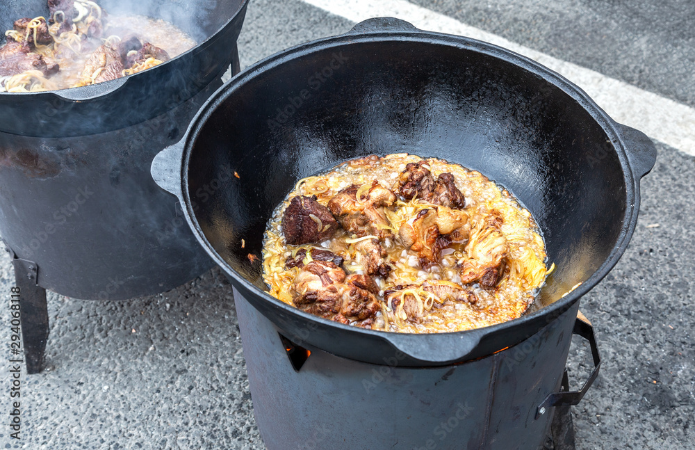 Pieces of meat cooking in a large cauldron Pieces of meat cooking in a large cauldron