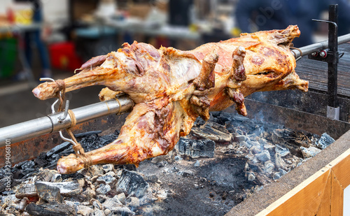 Cooking lamb carcass on a spit over hot charcoals