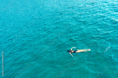 Women swimming alone under water in the sea view from above