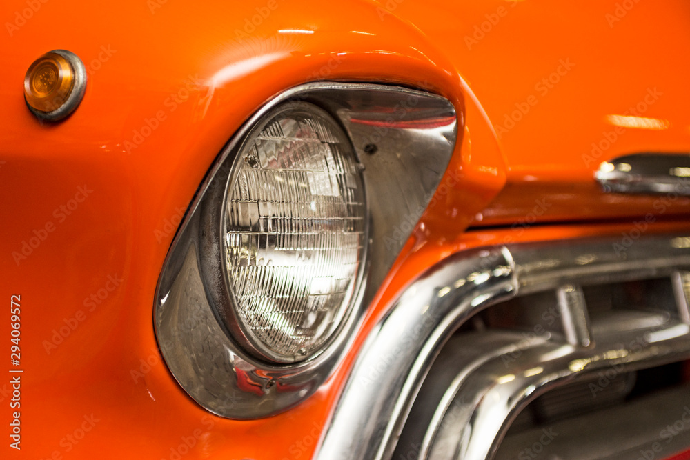 Headlight lamp vintage car. Classic car headlight. Close-up of headlights of orange vintage car. Exhibition