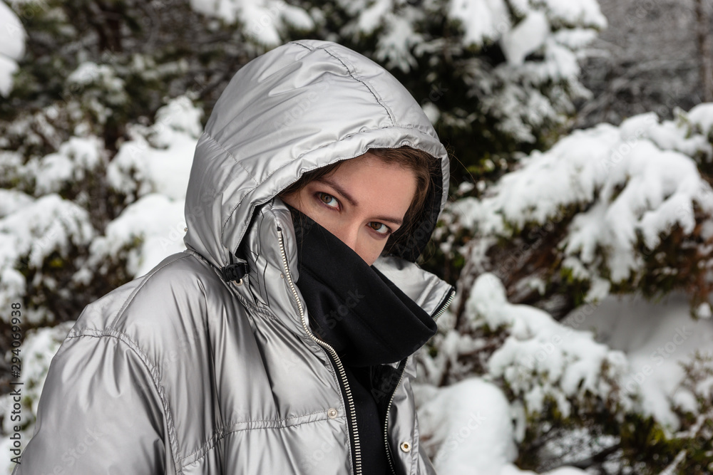 Obraz premium Close-up Lifestyle portrait of happy pretty young woman outdoors at snowing weather.