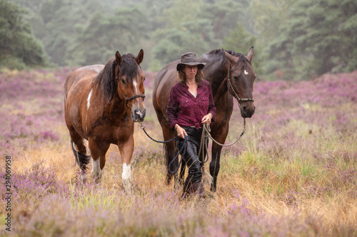 Frau wandert mit Pferden im Regen durch die Heide © Nadine Haase