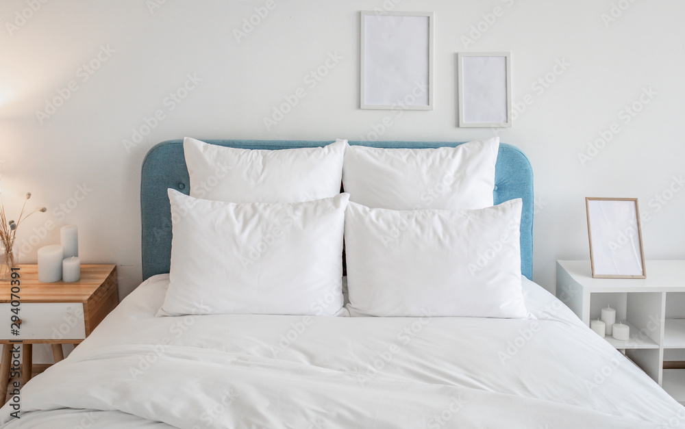 White pillows and duvet on the blue bed. White pillows, duvet and duvet case on a blue bed. White bed linen on a blue sofa. Bedroom with bed and bedding and poster frame mock up on the wall.Front view