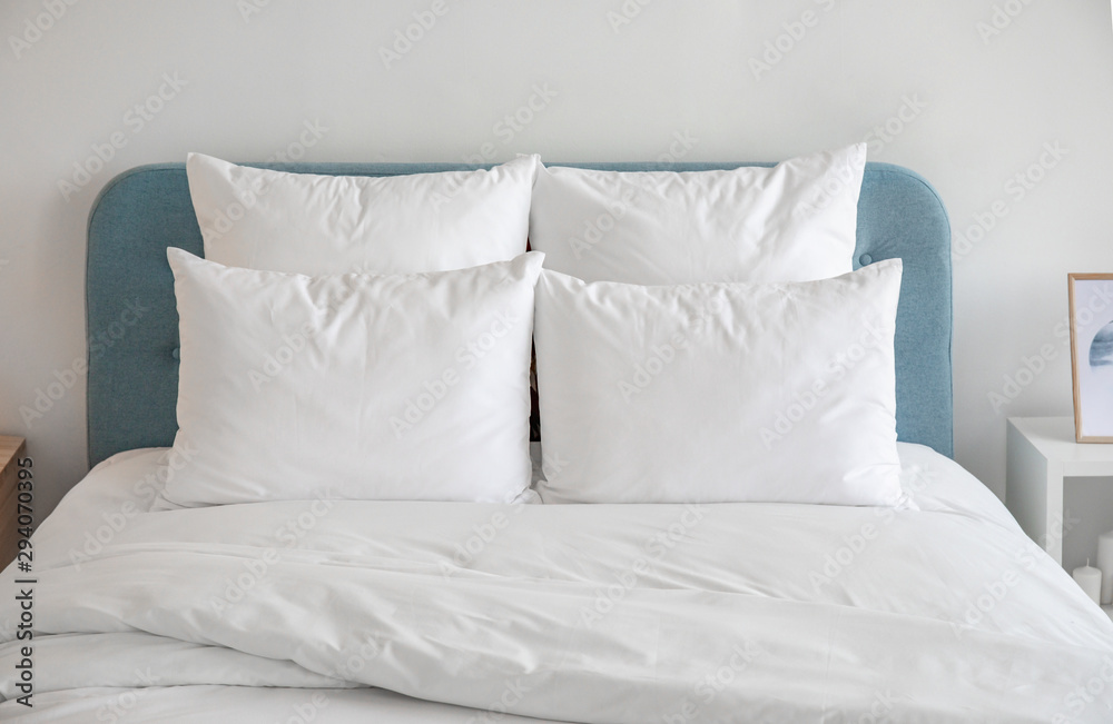 White pillows and duvet on the blue bed. White pillows, duvet and duvet case on a blue bed. White bed linen on a blue sofa. Bedroom with bed and bedding and poster frame mock up on the wall.Front view White pillows and duvet on the blue bed. White pillows, duvet and duvet case on a blue bed. White bed linen on a blue sofa. Bedroom with bed and bedding and poster frame mock up on the wall.Front view