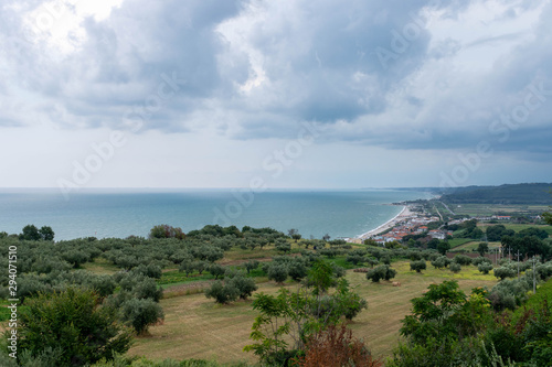 Landscape with countryside in the foreground, sea in the background and cloudy sky