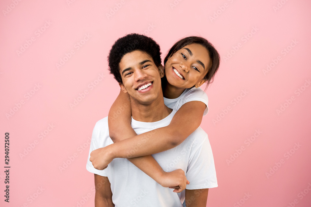 Loving girl embracing guy, posing to camera Loving girl embracing guy, posing to camera