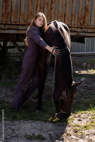 photo a woman in a suit hugs a horse