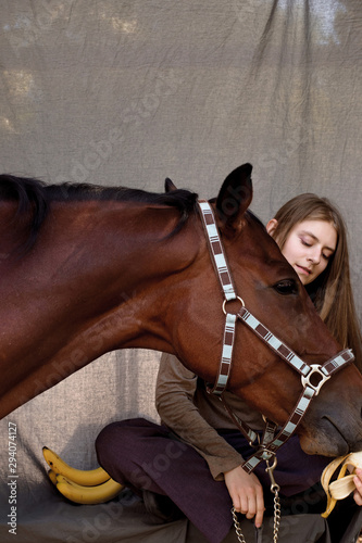 photo girl feeds her horse with bananas