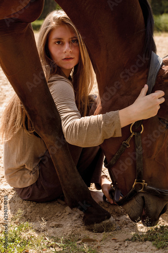 photo long-haired wild girl posing next to a horse in the sand portrait
