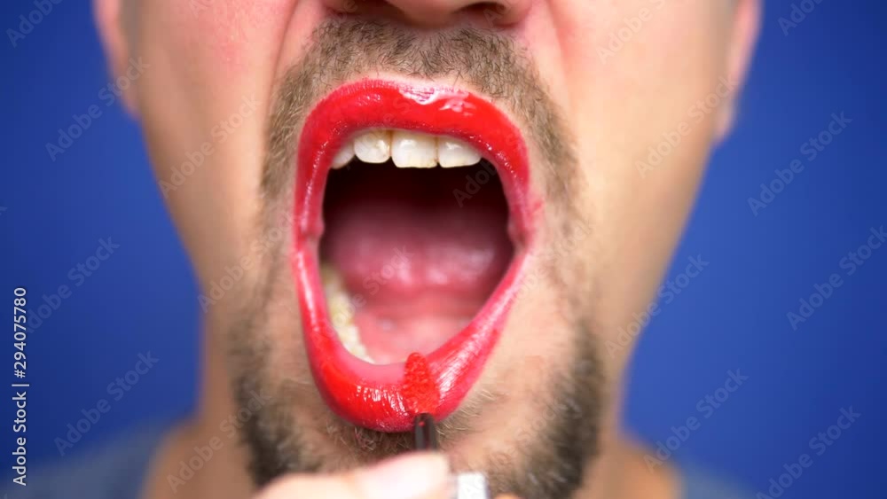 close-up. a bearded man paints his lips. close-up. a bearded man paints his lips.