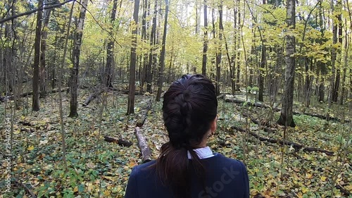 girl walks through the autumn forest, close-up head in the sun