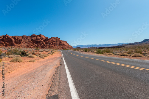 View of Large Red Sandstone Rock With 2 Lane road in the Foreground