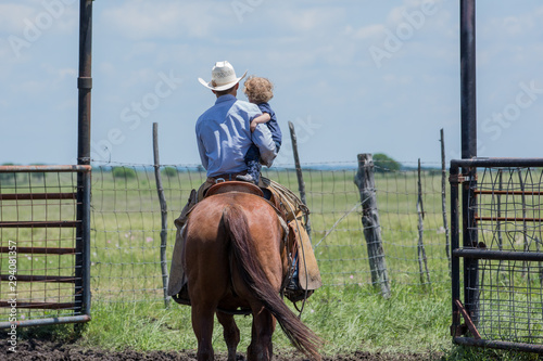 Cowboy and his child on horseback