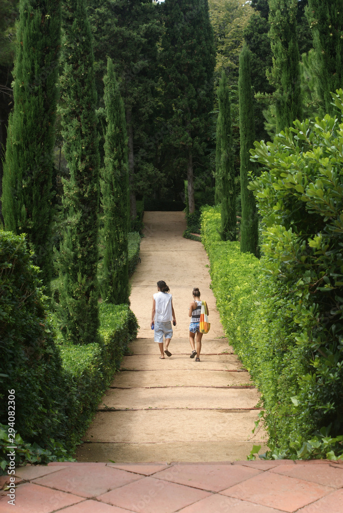 Two young people in love walking alongside each other in a Mediterranean, Roman Garden