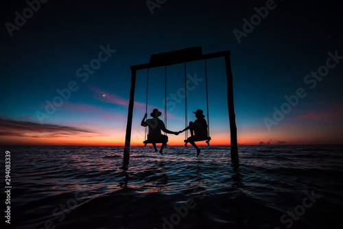 Couple contemplating an amazing sunset at Holbox Island in the Caribbean Ocean of Mexico photo