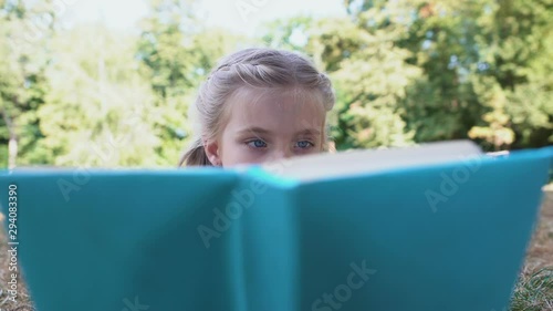 Concentrated schoolgirl reading fairytale book studying subject, knowledge