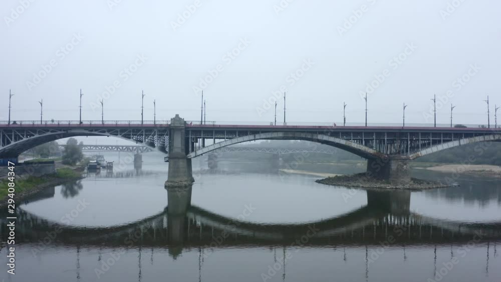 Aerial view of the river and bridge on a foggy day. Warsaw. Poland. Drone shot on a bridge with cars and public transport in the fog. 4K Drone Shot. Aerial view of the river and bridge on a foggy day. Warsaw. Poland. Drone shot on a bridge with cars and public transport in the fog. 4K Drone Shot.
