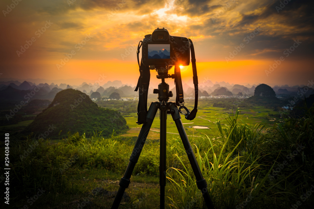 Camera on tripod and photography view camera with blurred focus landscape of sunset sunrise sun light sky cloud - obrazy, fototapety, plakaty 