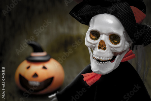 Halloween card with spooky skeleton and orange pumpkin on dark background © ReaLiia