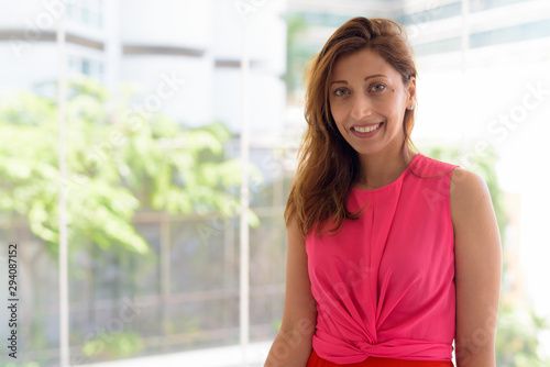 Happy beautiful Hispanic woman smiling by the window at home Free Download Happy beautiful Hispanic woman smiling by the window at home - GFXLoad