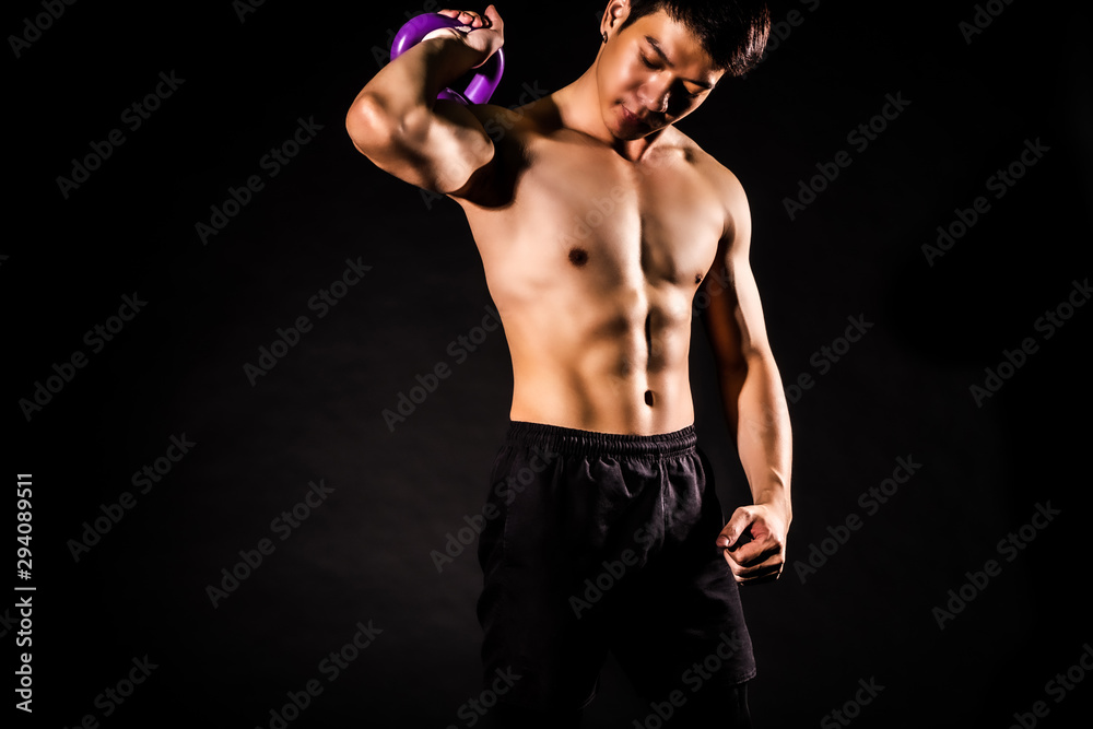 sport man at fitness gym club doing exercise for arms with kettlebell and showing muscle bodybuilding on black backgrounds, fitness concept, sport concept