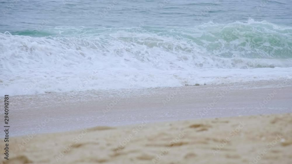 Wild ocean waves hitting the sandy beach - slow motion shot Wild ocean waves hitting the sandy beach - slow motion shot