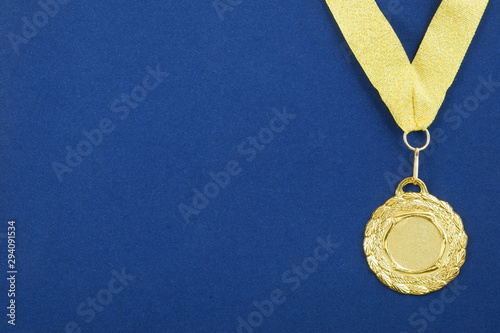 Gold medal with golden ribbon on blue background