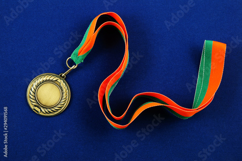 Gold medal with ribbon on blue background