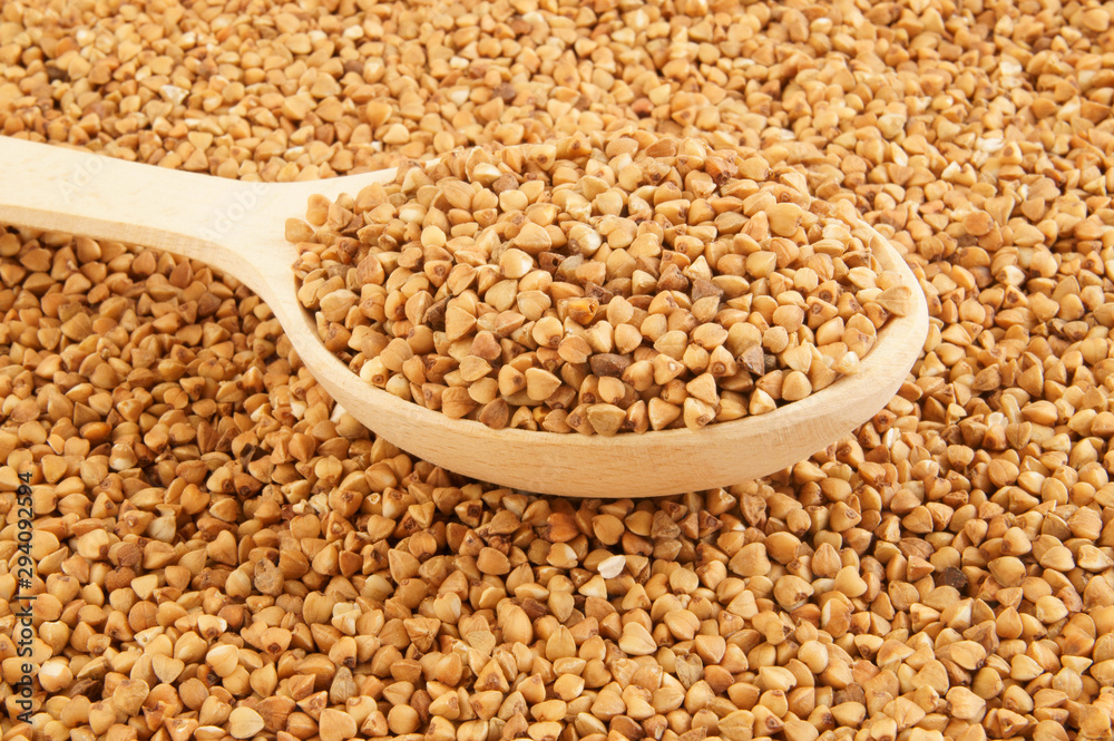 Fototapeta premium Buckwheat with wooden spoon close up