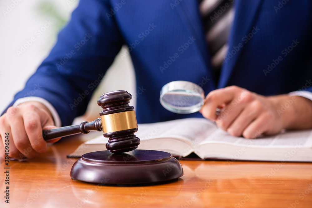 Young male judge sitting in courtroom Young male judge sitting in courtroom