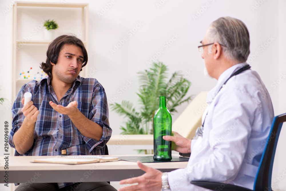 Young male alcoholic visiting old doctor Young male alcoholic visiting old doctor