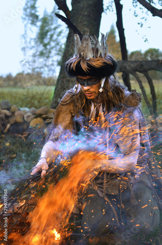young shaman conducts ritual about burning a fire