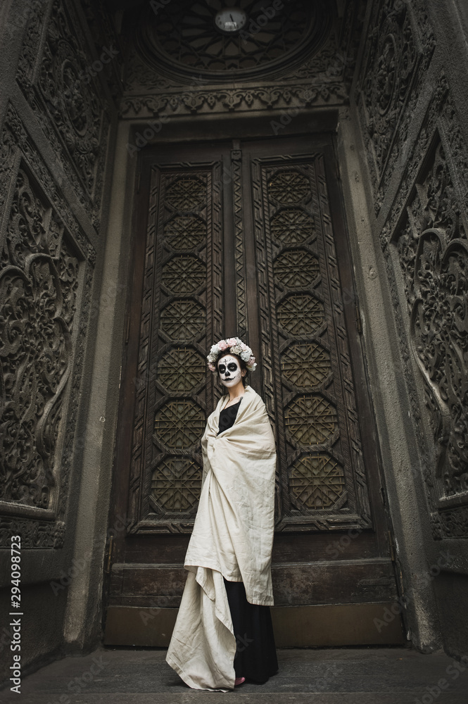 Calavera Catrina in the dark. Fashion model with sugar skull makeup. Dia de los muertos. Day of The Dead. Halloween.