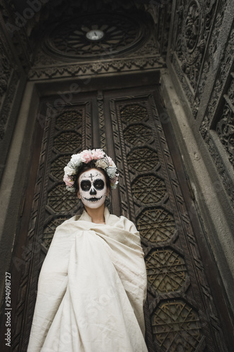 Calavera Catrina in the dark. Fashion model with sugar skull makeup. Dia de los muertos. Day of The Dead. Halloween. © Tetiana