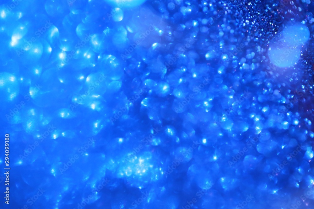 blue glitter  with bokeh background.Christmas festive winter background. texture with highlights. Blue shining bokeh surface. sparkling shiny  paper.Christmas holiday seasonal wallpaper