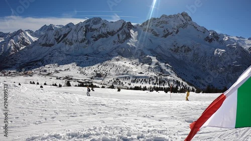 Ponte di Legno, Tonale, Italy. Amazing view of the ski slopes. Wonderful blue sky. POV. Skier helmet point of view. Italian flag