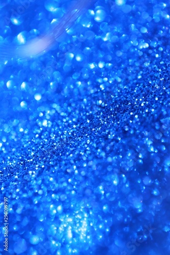 blue glitter with bokeh background.Christmas festive winter background.Shiny texture with highlights. Blue shining bokeh surface. sparkling shiny paper.Christmas seasonal wallpaper