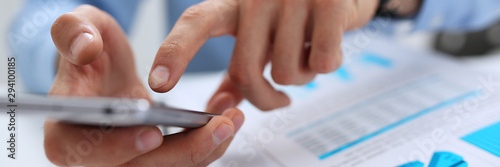 A businessman holds a new smartphone in his hand The mobile application market shows a display you can insert your image for advertising or financial statistics.