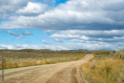 Winding dirt road among the hills with desert like landscape  grasslands and bush in Kamloops  British Columbia. Lac Du Bois