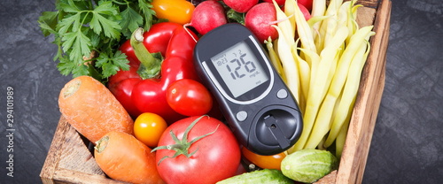 Glucometer with fresh vegetables as source minerals and vitamins. Diabetes, healthy lifestyles and dieting