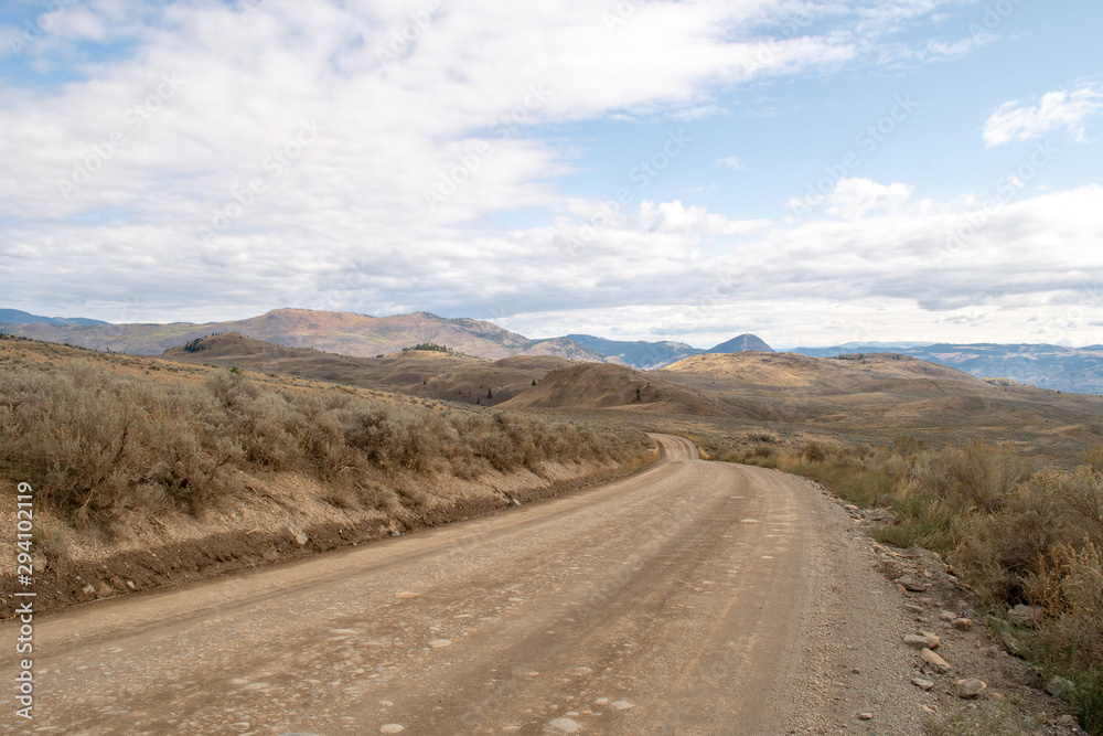 Dirt winding road in the mountains in the rural pasture lands on the hills in Lac Du Bois Grasslands protected area, Kamloops