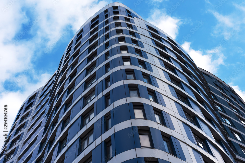 The appearance of new high-rise buildings made of glass and concrete on a blue sky background The appearance of new high-rise buildings made of glass and concrete on a blue sky background