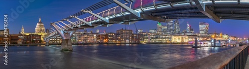Night panorama of the Thames river with Millennium bridge and Saint Paul's Cathedral and the City skyline in the background. Panoramic view cityscape of London, United Kingdom photo