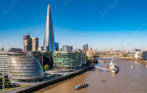 Aerial cityscape of the Thames river on a sunny day with the City Hall, Shard skyscraper and London skyline.