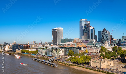 Aerial cityscape of the Thames river on a sunny day with the City Financial district skyscrapers and Tower of London.