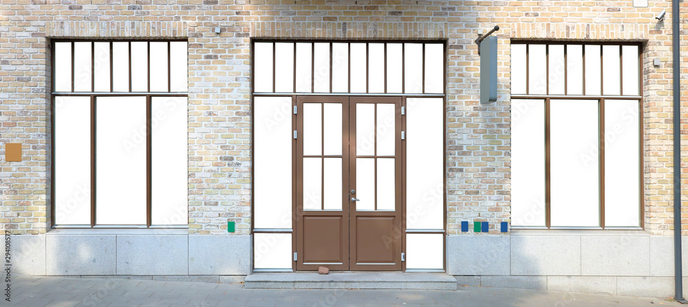 Modern mass production brown plastic window frames and door is built in in a brick wall Modern mass production brown plastic window frames and door is built in in a brick wall