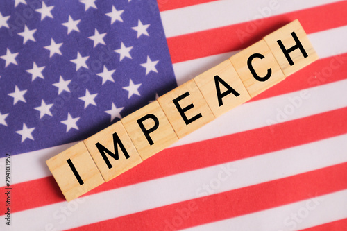 Concept of US politics, Impeachment showing with US flag with Impeach in wooden letters.