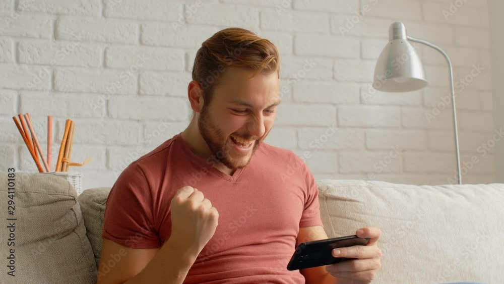 Sports Fan Reaction Concept - Excited sports fan watching his favourite team/player on smart phone, 4k Sports Fan Reaction Concept - Excited sports fan watching his favourite team/player on smart phone, 4k